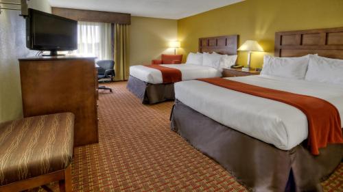 a hotel room with two beds and a flat screen tv at Holiday Inn Express Greenville, an IHG Hotel in Greenville