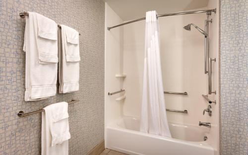a bathroom with a shower and a bath tub with towels at Holiday Inn Express El Paso I-10 East by IHG in El Paso