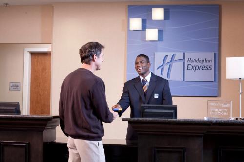 a man standing in front of a podium in front of a projector screen at Holiday Inn Express Newton, an IHG Hotel in Newton