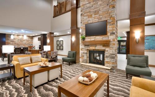 a lobby with a fireplace in a hotel at Staybridge Suites - Gainesville I-75 by IHG in Gainesville