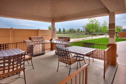 a patio with tables and chairs and a grill at Candlewood Suites Grand Junction by IHG in Grand Junction