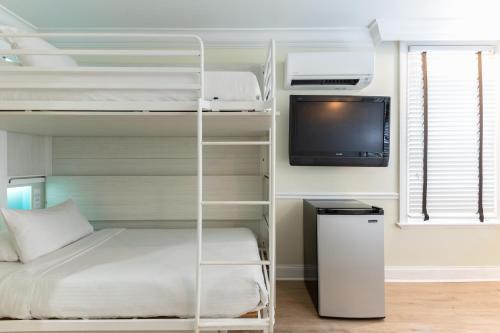 a bedroom with a bunk bed and a tv at Nyah - Adult Exclusive in Key West