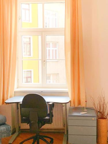 een bureau en een stoel voor een raam bij Pension Huber - Apartement Wien 9 in Wenen