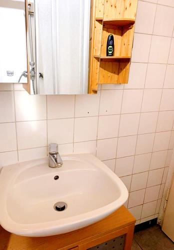een badkamer met een witte wastafel en een spiegel bij Pension Huber - Apartement Wien 9 in Wenen