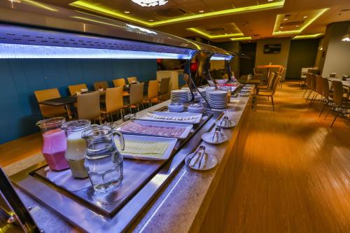 a long table in a restaurant with chairs and tables at Go Inn Santo André in Santo André
