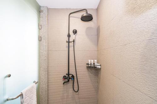 a shower with a shower head in a bathroom at Zen Tea House Seven Stars Park in Guilin