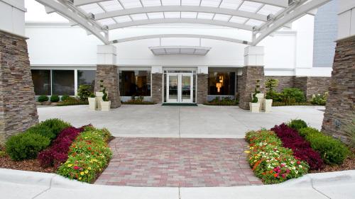 a large building with flowers in a courtyard at Holiday Inn Grand Haven-Spring Lake by IHG in Spring Lake