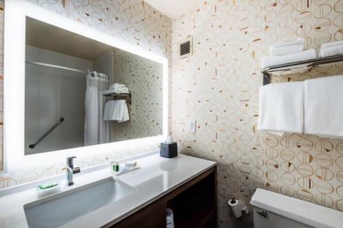a bathroom with a white sink and a mirror at Holiday Inn Grand Haven-Spring Lake by IHG in Spring Lake