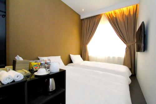 a hotel room with two beds and a window at Arton Boutique Hotel in Singapore