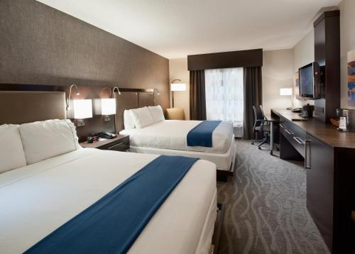 ein Hotelzimmer mit 2 Betten und einem Schreibtisch in der Unterkunft Holiday Inn Express & Suites Dayton South - I-675, an IHG Hotel in Shanersville