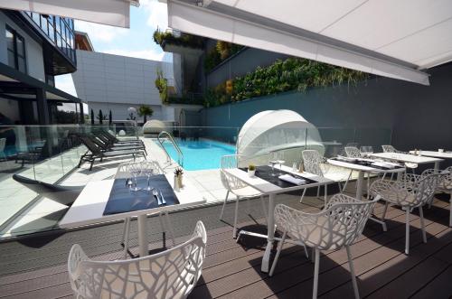 a patio with tables and chairs and a swimming pool at Holiday Inn Dijon Toison D'or by IHG in Dijon
