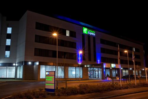 a hospital building with a lit up sign at night at Holiday Inn Express Rotherham - North, an IHG hotel in Rotherham