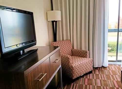 a hotel room with a television and a chair at Holiday Inn Irving Las Colinas by IHG in Irving