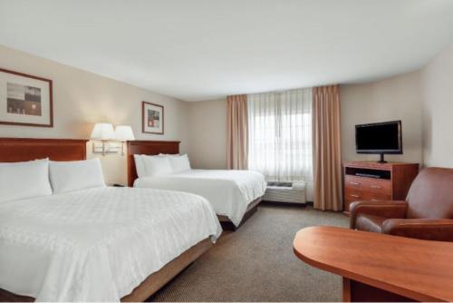 Un pat sau paturi într-o cameră la Candlewood Suites Gillette, an IHG Hotel