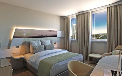 um quarto de hotel com uma cama king-size e uma secretária em Holiday Inn Frankfurt Airport, an IHG Hotel em Frankfurt am Main