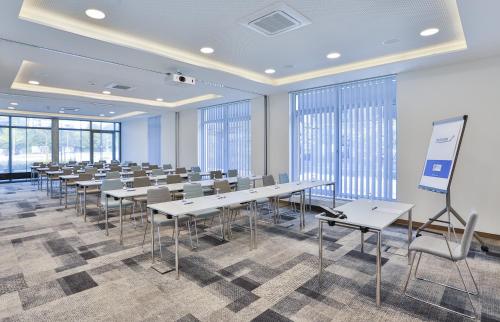 a conference room with tables and chairs and windows at Holiday Inn Express Karlsruhe - City Park by IHG in Karlsruhe