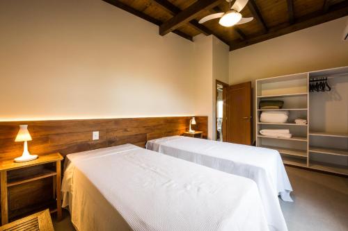 a hotel room with a bed, desk, and nightstand at Fazenda Verde - Praia do Rosa in Praia do Rosa