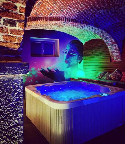 a jacuzzi tub with a statue in a room at La Belle Étable in Dinant