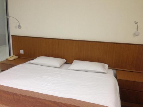 a large bed with two white pillows on it at New Cape Inn in Singapore
