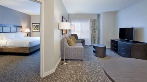 a hotel room with a bed and a tv and a bedroom at Candlewood Suites Kearney by IHG in Kearney