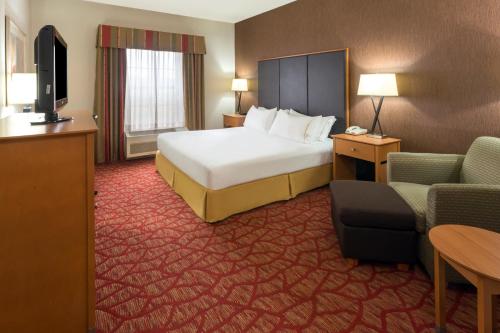 a hotel room with a bed and a couch and a television at Holiday Inn Express Grants Pass by IHG in Grants Pass
