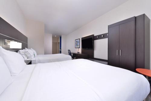 a hotel room with a large white bed and a television at Holiday Inn Express Mystic by IHG in Mystic