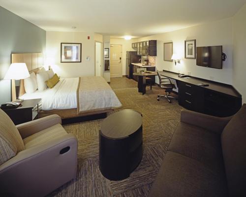 a hotel room with a bed and a desk at Candlewood Suites Fort Collins by IHG in Fort Collins