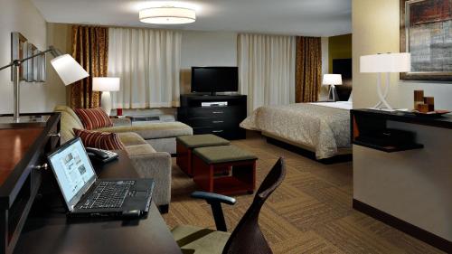 a hotel room with a laptop computer on a desk at Staybridge Suites Dearborn by IHG in Dearborn