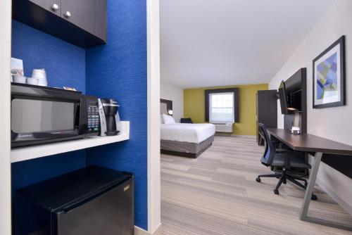 a hotel room with a bed a desk and a microwave at Holiday Inn Express Mystic by IHG in Mystic