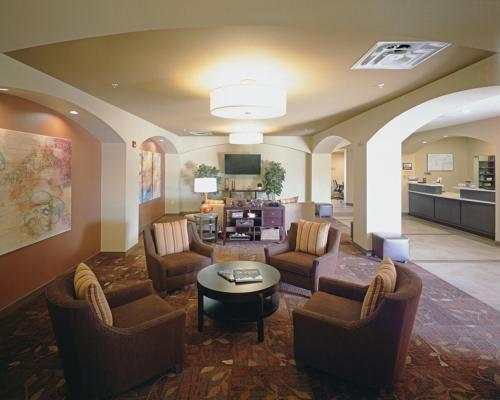 una gran sala de estar con sofás y una mesa. en Candlewood Suites Fort Collins, an IHG Hotel, en Fort Collins