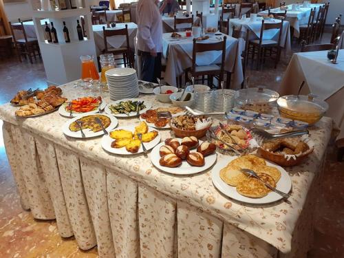 una mesa con platos de comida encima en Hotel Lory, en Garda