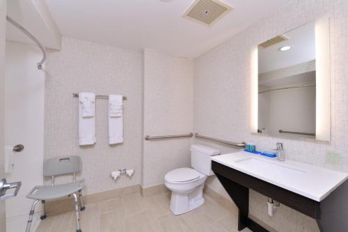 a bathroom with a toilet and a sink and a mirror at Holiday Inn Express Mystic by IHG in Mystic