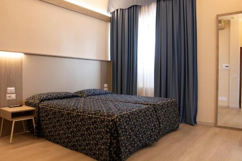 a bedroom with a bed and a large window at Hotel Mediterraneo in Civitavecchia