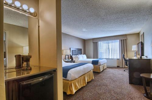 a hotel room with two beds and a television at Holiday Inn Express Detroit-Birmingham, an IHG Hotel in Birmingham