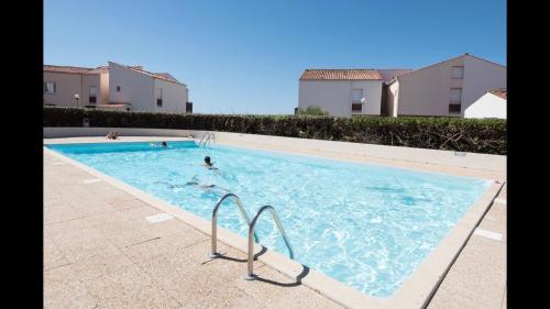 - une piscine avec 2 personnes dans l'eau dans l'établissement Appartement vue imprenable, à La Rochelle