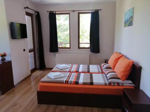 a small bedroom with a bed and a window at Къща за гости ДАЯНИЦА in Kopilovtsi
