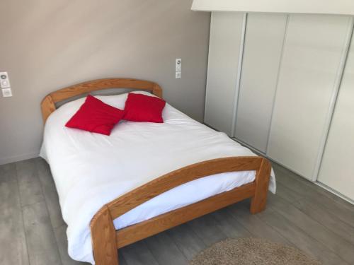 a bedroom with a bed with two red pillows on it at Appartement vue imprenable in La Rochelle