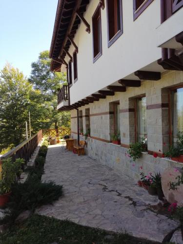 a building with a stone walkway in front of it at Къща за гости ДАЯНИЦА in Kopilovtsi