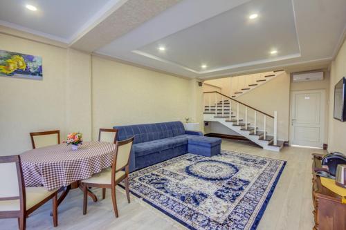 a living room with a blue couch and a table at Karagat Hotel in Karakol
