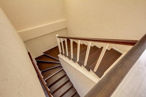 a spiral staircase in a building with wooden rails at Karagat Hotel in Karakol