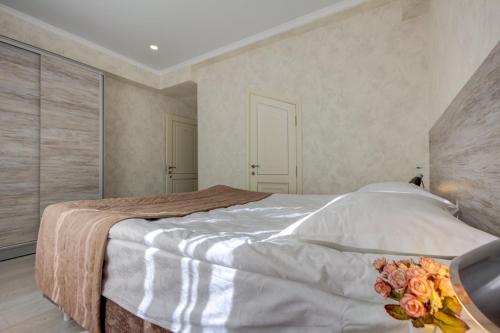 a bedroom with a large bed with flowers on it at Karagat Hotel in Karakol
