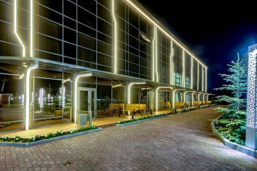 a large building with a christmas tree in front of it at Karagat Hotel in Karakol