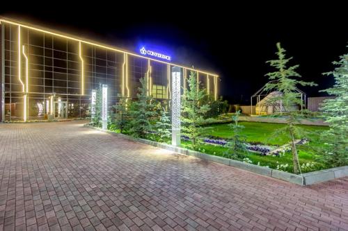 a building with a lit sign on the side of it at Karagat Hotel in Karakol
