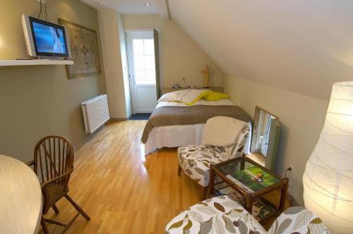 um quarto no sótão com uma cama, uma mesa e cadeiras em Abeljano em Hasselt