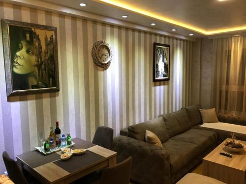 uma sala de estar com um sofá e uma mesa em VIP Apartman KIKA Zlatibor em Zlatibor