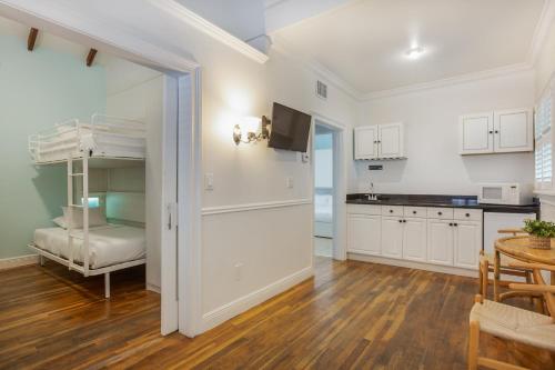 a kitchen with white cabinets and a table and a room at Nyah - Adult Exclusive in Key West