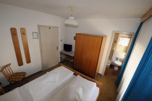 a bedroom with a bed and a desk with a computer at Ciasa Soreghina in Colfosco