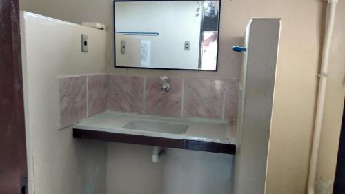 a bathroom with a sink and a mirror on the wall at Pousada Village Maçarico in Salinópolis