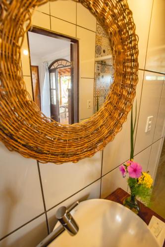 a bathroom with a sink and a mirror at Pousada Areia Preta in Cumuruxatiba