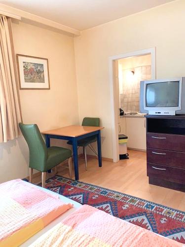 Schlafzimmer mit einem Schreibtisch, einem TV und einem Bett in der Unterkunft Pension Huber - Apartement Wien 20 in Wien